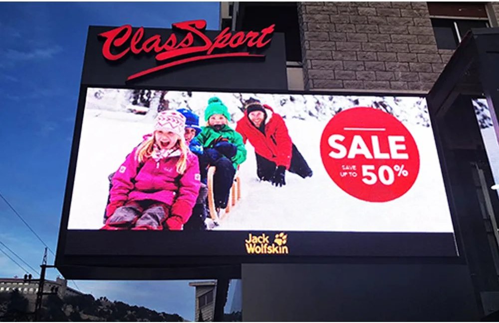 Digital advertising board on a building exterior with strong color contrast for daytime visibility